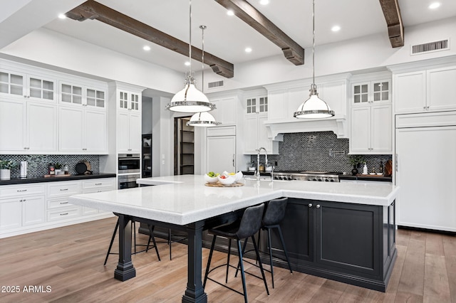 13750 E Yucca St, Scottsdale, AZ 85259 - kitchen with beam ceiling, decorative backsplash, stainless steel double oven, a spacious island, and white cabinets