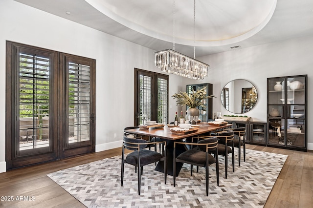 13750 E Yucca St, Scottsdale, AZ 85259 - dining room with baseboards, wood-type flooring, a chandelier, and a raised ceiling