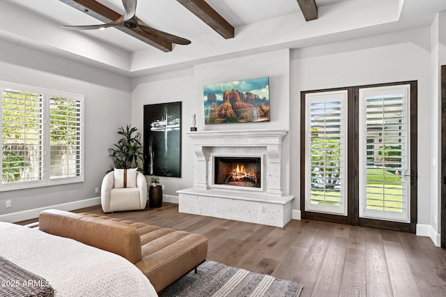 13750 E Yucca St, Scottsdale, AZ 85259 - living area with baseboards, ceiling fan, wood-type flooring, a fireplace, and beam ceiling