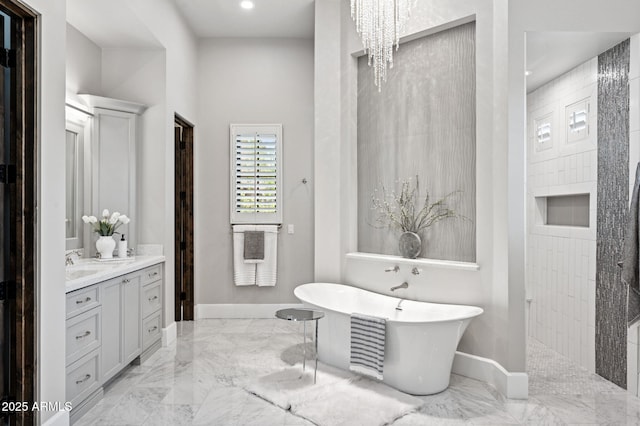 13750 E Yucca St, Scottsdale, AZ 85259 - bathroom with marble tiled floors, a freestanding bath, baseboards, vanity, and recessed lighting