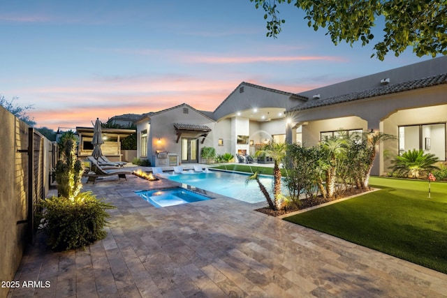 13750 E Yucca St, Scottsdale, AZ 85259 - pool at dusk featuring an in-ground hot tub, a patio area, an outdoor pool, and a putting area
