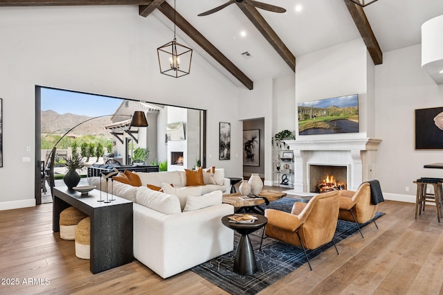 13750 E Yucca St, Scottsdale, AZ 85259 - living area with a warm lit fireplace, high vaulted ceiling, wood finished floors, beamed ceiling, and baseboards