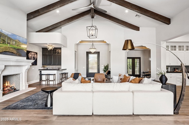 13750 E Yucca St, Scottsdale, AZ 85259 - living area with beam ceiling, a lit fireplace, high vaulted ceiling, wood finished floors, and a chandelier