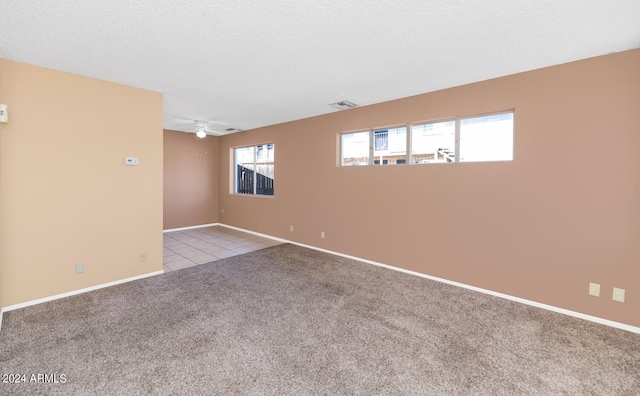 tiled spare room with ceiling fan and a textured ceiling