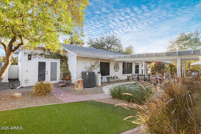 back of property with central AC unit, a yard, a patio area, and french doors