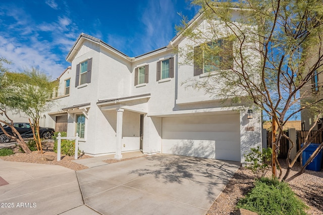 view of front facade featuring an attached garage, driveway, and stucco siding