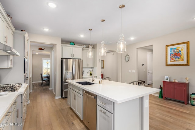 kitchen featuring pendant lighting, sink, white cabinetry, an island with sink, and stainless steel appliances