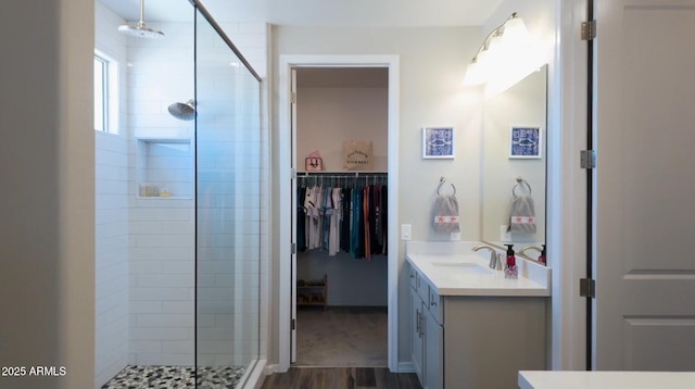 bathroom featuring hardwood / wood-style flooring, a shower with shower door, and vanity