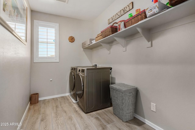 clothes washing area featuring light hardwood / wood-style flooring and washing machine and clothes dryer