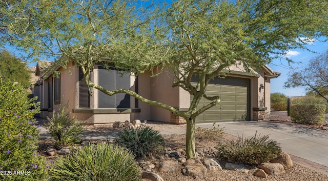 view of front of house featuring driveway, a garage, and stucco siding