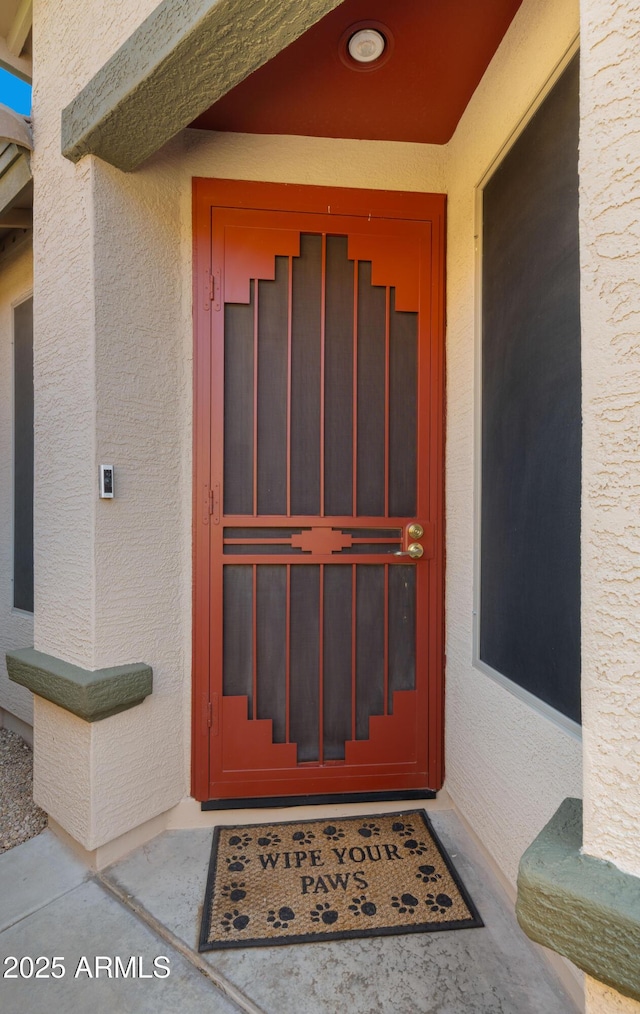 view of exterior entry featuring stucco siding