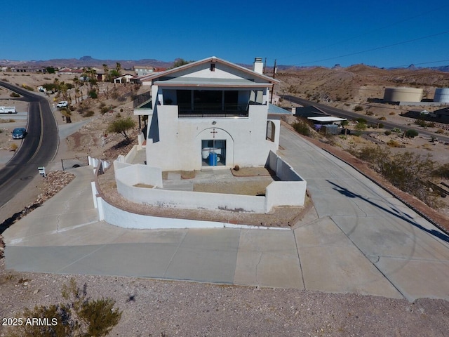 view of front of home with a chimney, a mountain view, and stucco siding