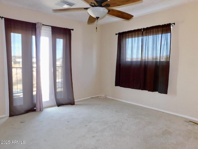 empty room with visible vents, ceiling fan, light carpet, and baseboards