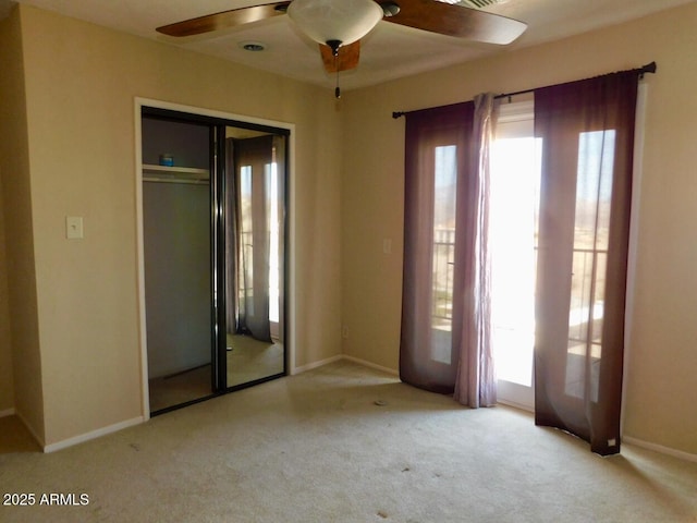 unfurnished room with light colored carpet, ceiling fan, and baseboards