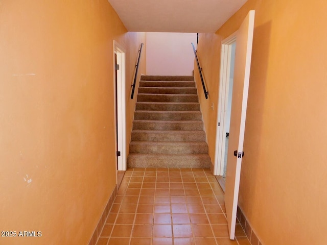 stairway featuring baseboards and tile patterned floors