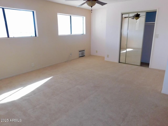 unfurnished bedroom with a closet, a ceiling fan, and light colored carpet