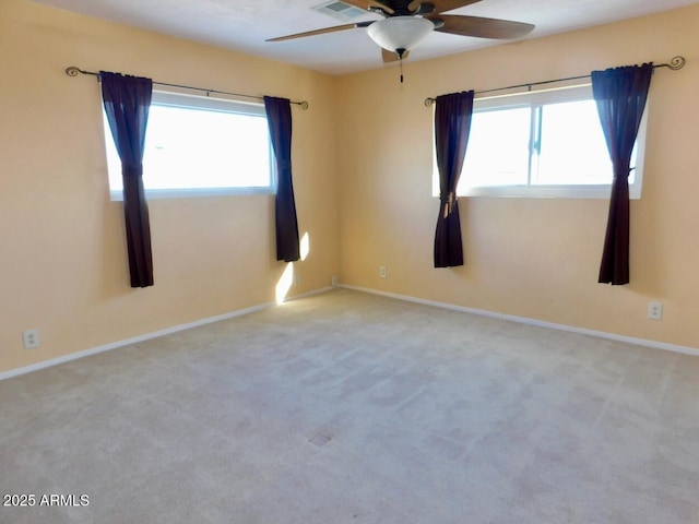 empty room with baseboards, a wealth of natural light, and light colored carpet