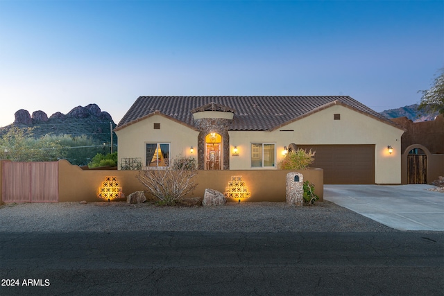 view of front of home featuring driveway, a fenced front yard, a tiled roof, and stucco siding