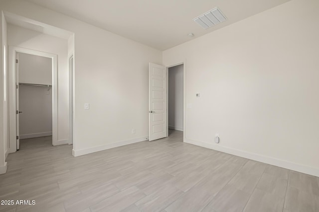 unfurnished bedroom with baseboards, visible vents, and light wood-style flooring