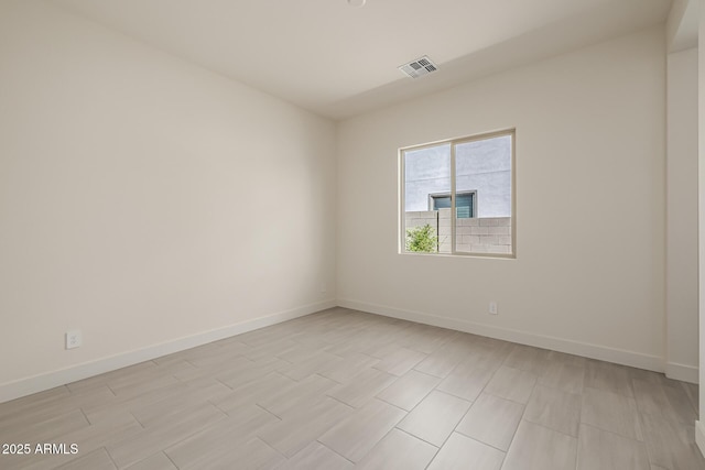 unfurnished room with baseboards and visible vents