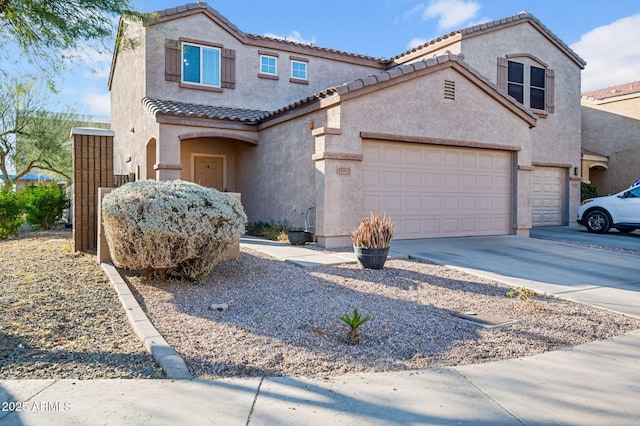 view of front of property featuring concrete driveway, an attached garage, a tiled roof, and stucco siding