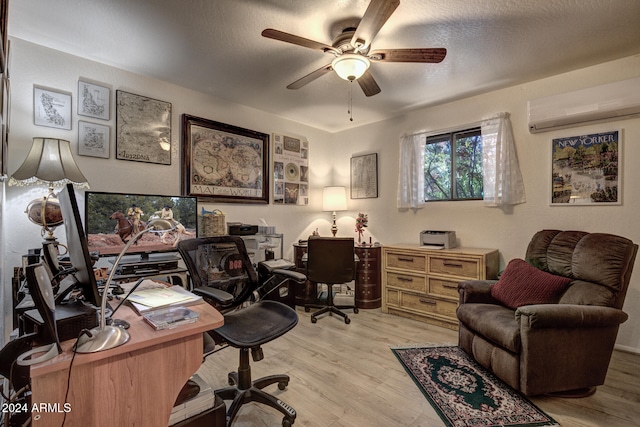 home office with a textured ceiling, light hardwood / wood-style flooring, an AC wall unit, and ceiling fan