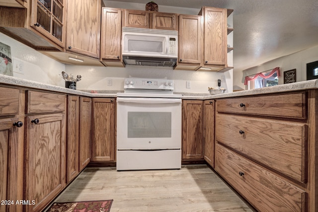 kitchen featuring white appliances and light hardwood / wood-style flooring