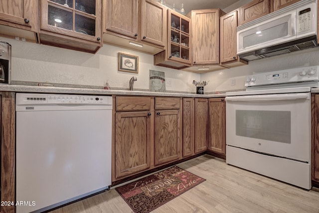 kitchen with white appliances and light hardwood / wood-style flooring