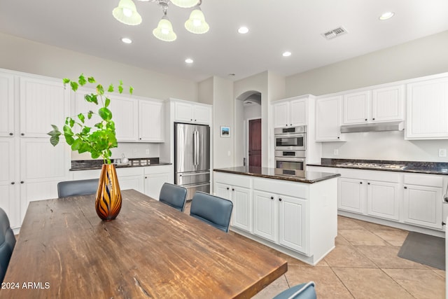 kitchen with stainless steel appliances, a center island, pendant lighting, light tile patterned floors, and white cabinets