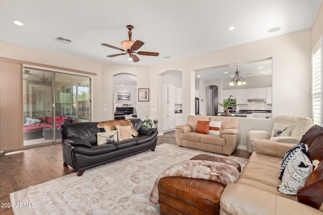 living room featuring a wealth of natural light, light hardwood / wood-style flooring, and ceiling fan with notable chandelier