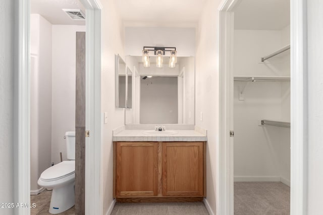 30212 N Sunray Dr, San Tan Valley, AZ 85143 - bathroom featuring toilet, vanity, a walk in closet, and baseboards