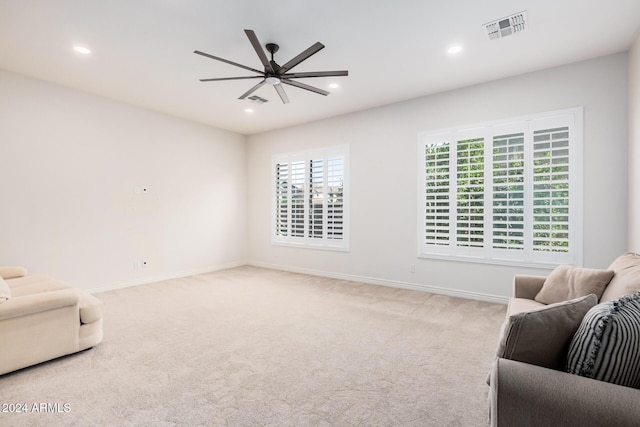 sitting room featuring light colored carpet and ceiling fan