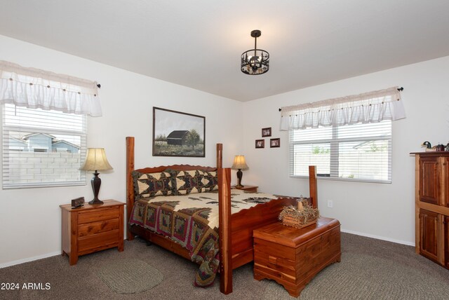 carpeted bedroom with a notable chandelier