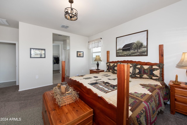 bedroom with dark carpet and a notable chandelier