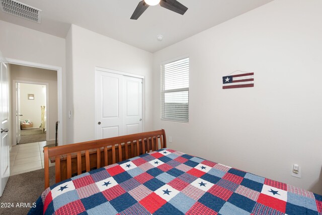 bedroom featuring dark carpet, a closet, and ceiling fan