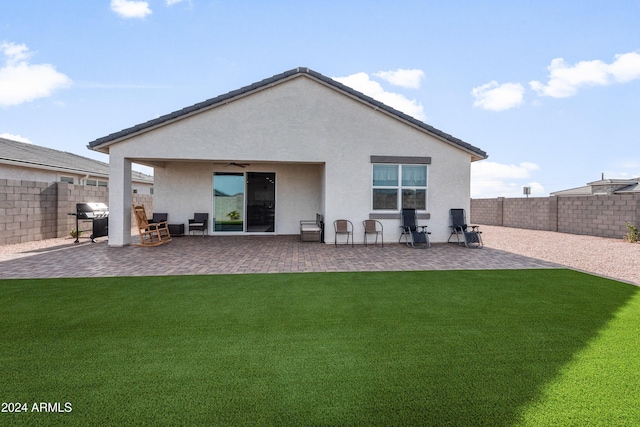 back of house featuring ceiling fan, a patio area, and a yard