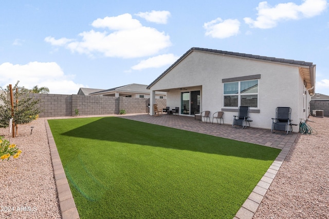 back of house featuring central AC, ceiling fan, a patio area, and a lawn