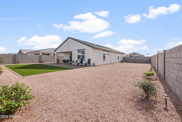 back of property with a patio area and a yard