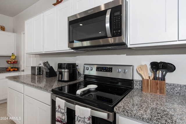 kitchen with white cabinets, stainless steel appliances, and light stone counters