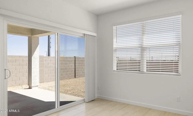 doorway featuring plenty of natural light, baseboards, and wood finished floors