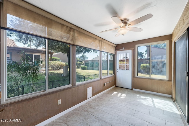 unfurnished sunroom featuring ceiling fan