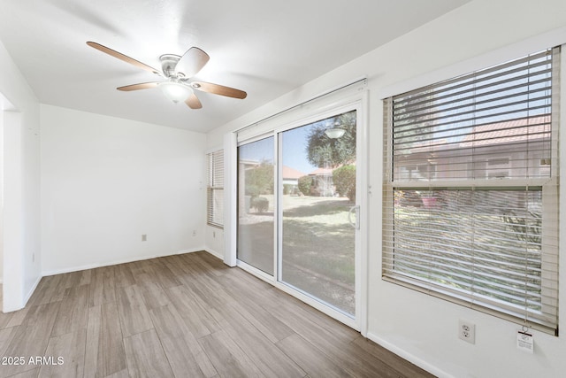 empty room with ceiling fan, baseboards, and wood finished floors