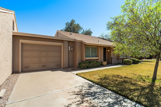 view of front facade featuring an attached garage, a shingled roof, concrete driveway, stucco siding, and a front yard