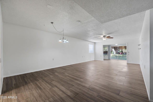 unfurnished living room featuring ceiling fan with notable chandelier, a textured ceiling, baseboards, and wood finished floors