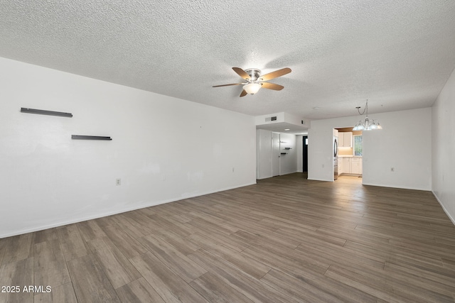 unfurnished living room with a textured ceiling, visible vents, wood finished floors, and ceiling fan with notable chandelier