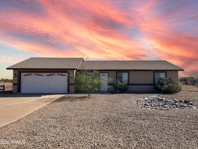 single story home with a garage, concrete driveway, and stucco siding