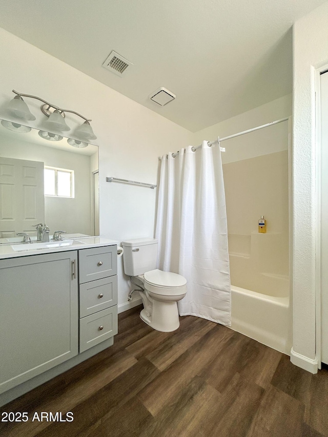 bathroom featuring toilet, wood finished floors, shower / bathtub combination with curtain, and vanity
