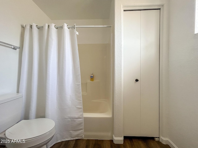 full bathroom featuring toilet, wood finished floors, and shower / bathtub combination with curtain