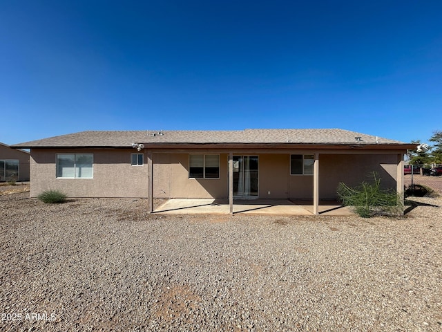 rear view of house featuring stucco siding and a patio area
