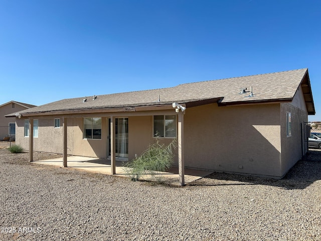 back of property featuring a patio, a shingled roof, and stucco siding